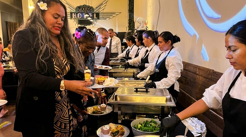 Guests serve themselves from a buffet line with staff attending chafing dishes at Woods Hotel.